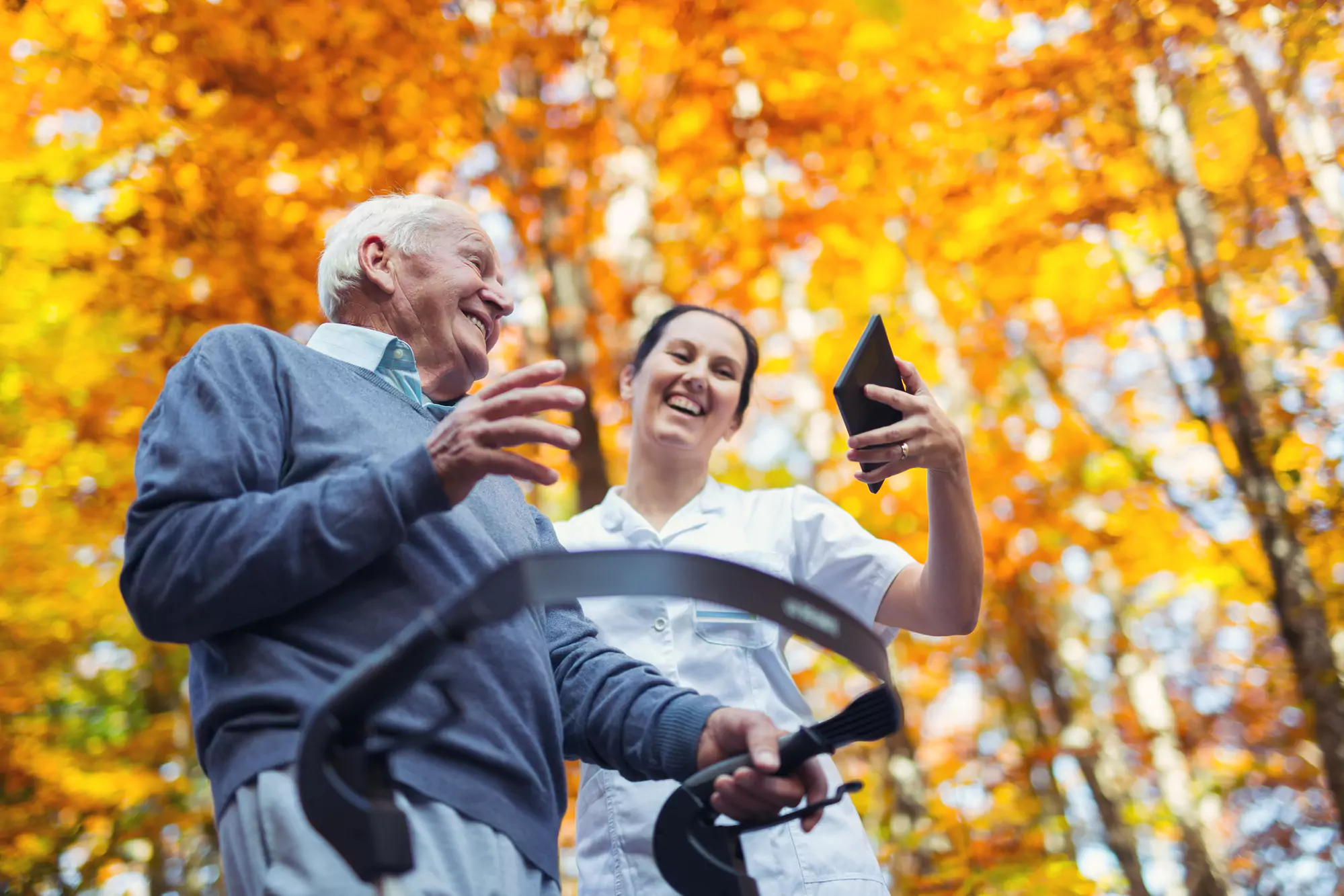 home-health-care-aide-walking-outside-with-an-elderly-man